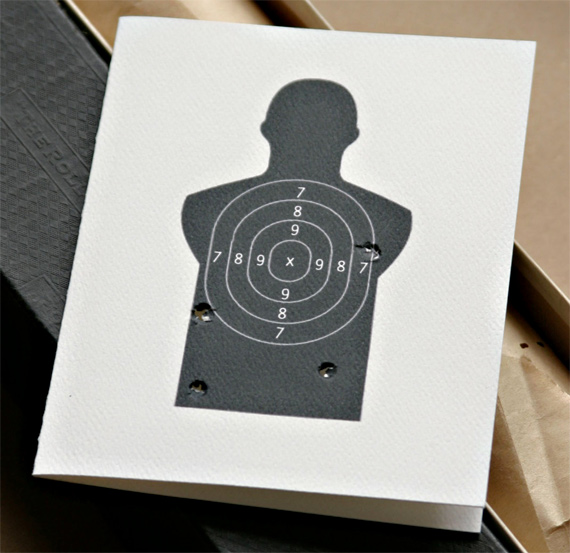 A card to say I Miss You A greeting card with a shooting range target on it with bullet holes around the edges