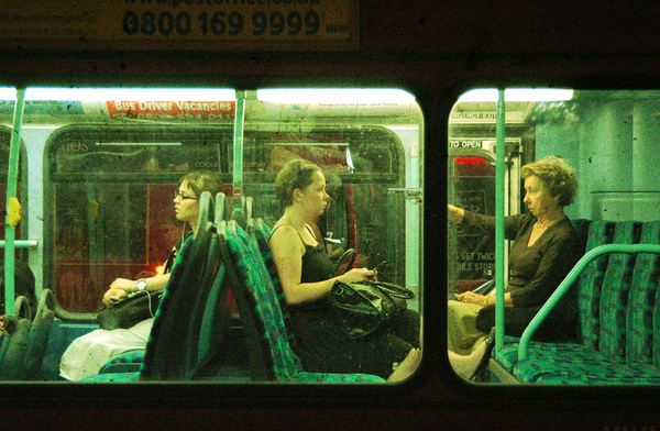 An image of an old lady pointing a gun at a young lady in a subway